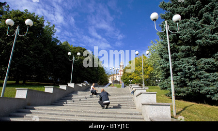 Ein Mann nimmt ein Bild von seiner Freundin in einem Park in Minsk, Weißrussland Stockfoto