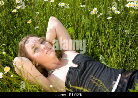 Junge schöne Frau, die Verlegung auf dem Rasen Stockfoto