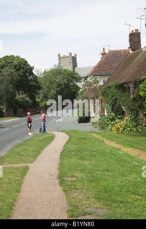 Zwei Frauen plaudern auf der Strasse mit Kirche und hübschen Cottages Orford, Suffolk Stockfoto