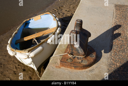 Kleines Ruderboot festgemacht, bei Ebbe auf dem Fluss Glaven am Hafen von Blakeney, North Norfolk Küste Stockfoto