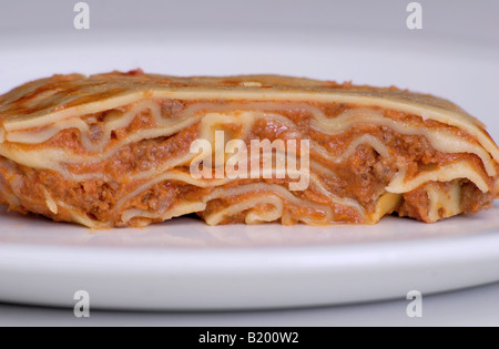 Italienisches Essen Lasagne zeigt Querschnitt durch Schichten von Nudeln und Hackfleisch auf einem weißen Teller Stockfoto