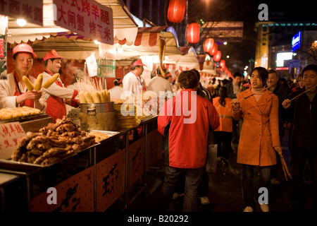 Käufer übergeben Verkaufsständen, Fleisch-Spieße und Mais auf die Kolben in der Nacht Markt Wangfujing Street Peking China Stockfoto
