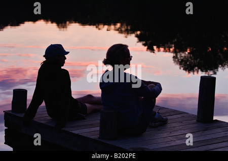 Mutter und Tochter, die Standortwahl auf Silhouette gegen Reflexion des Sonnenuntergangs Dock Mount Saint Francis Indiana Stockfoto