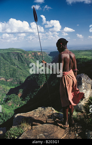 Samburu Krieger oder Moran in traditioneller Kleidung bewaffnet mit einem Speer auf der Suche nach unten die El Kajarta Schlucht nördlichen Kenia in Ostafrika Stockfoto
