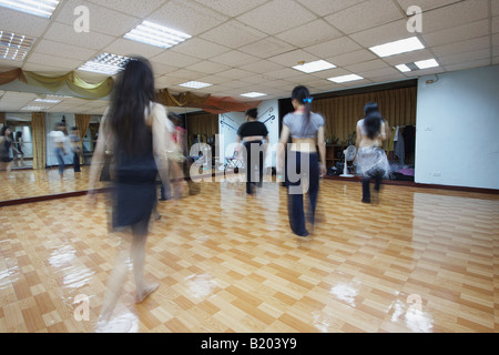 Chinesische Frauen üben Tanz-Routine vor Spiegel im Tanzstudio Stockfoto