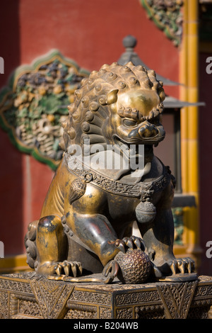 Vergoldete männlicher Löwenstatue mit Ball unter Pfote in der kaiserlichen Palast-verbotene Stadt-Beijing-China Stockfoto