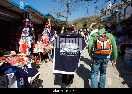 Touristen gehen vorbei an Souvenir t-Shirt besagt, dass ich auf die große Mauer bei Mutianyu nördlich von Beijing geklettert bin Stockfoto