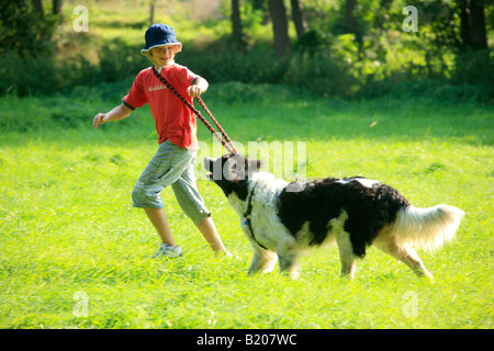 ein kleiner Junge mit seinem Hund ausführen Stockfoto