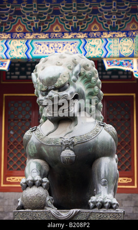 Statue eines Bronze männlichen Löwen mit Pfote auf einen Ball an den Sommerpalast Peking China Stockfoto