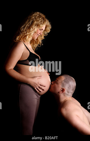Studioaufnahme von ein Mann seine schwangere Frau Bauch küssen Stockfoto