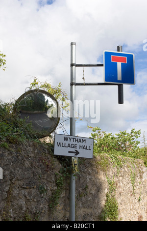 Ein konkaver Spiegel zeigt eine Straßenkreuzung nicht durch Strasse zu unterzeichnen und Dorfhalle Wytham Oxfordshire Stockfoto