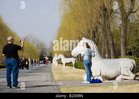 Touristischen posiert mit Statue von einem ruhenden Pferd Geist Weg Ming Gräber Beijing Peking China Stockfoto