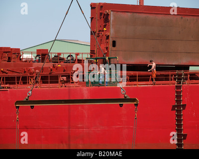 Zwei Männer, die auf eine sehr große rote Schiff Hafen von Antwerpen Flandern Belgien arbeiten Stockfoto