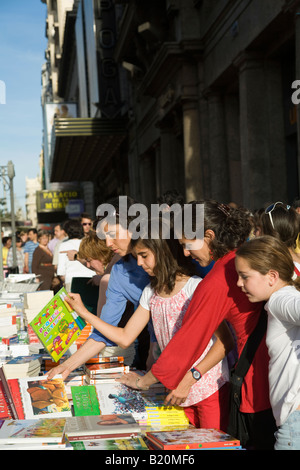 Spanien Madrid Erwachsene Frauen und Kinder schauen Bücher zum Verkauf auf Tisch auf Bürgersteig Stockfoto