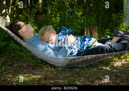 Prairieville Michigan ein zweijähriger Junge entspannt mit seiner Mutter in einer Hängematte Stockfoto