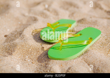 Paar grüne Flip flops am Strand. Stockfoto