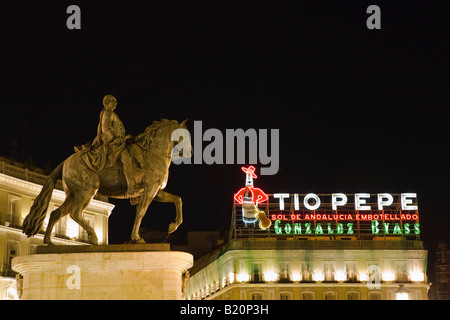 Spanien Madrid Statue of montiert König Charles III in Puerto del Sol Plaza mit Tio Pepe Leuchtreklame in der Nacht Stockfoto