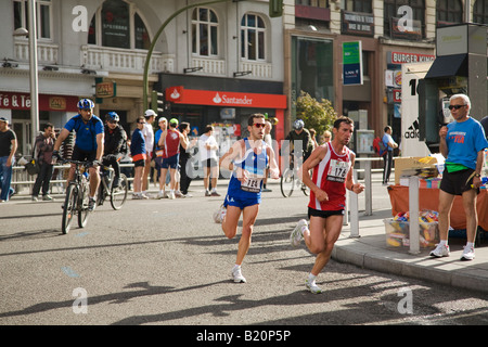 Spanien Madrid männliche Läufer im Marathonlauf auf Gran Via Straße mit dem Fahrradfahrer und Zuschauer Stockfoto