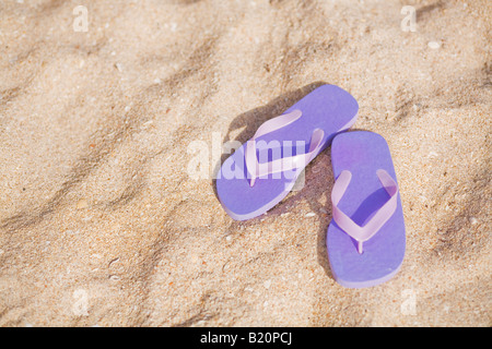 Paar lila Flip flops am Strand. Stockfoto