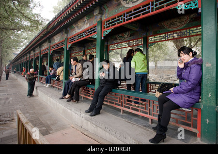 Besucher sitzen entlang der langen Korridor Chang Lang an der Sommerpalast Peking China Stockfoto