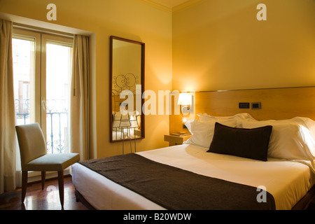 Spanien Madrid Queensize-Bett im Hotel Zimmer Spiegel und Nachttisch zeitgenössischen modernen europäischen Unterkünfte Stockfoto