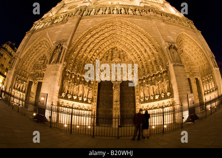 Paar vor der Westfassade der Kathedrale Notre-Dame mit Flutlicht beleuchteten Illuminationen in Abend, Nacht-Licht-Paris Frankreich Stockfoto
