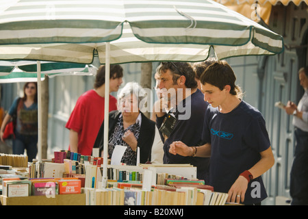 Spanien-Madrid-Männer und Frauen betrachten Sie gebrauchte Bücher angezeigt auf Tisch unter Dach Stockfoto