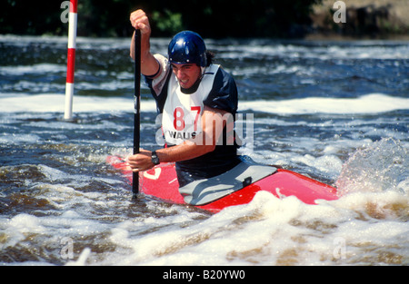 Kajak fahren C1 männliche Kajak Paddler Graben mit Paddel, Slalom-Tor auf Wildwasser-Rennen-Kurs zu manövrieren Stockfoto