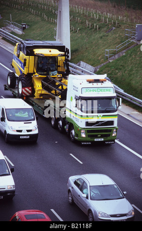 Tieflader LKW transportieren Mähdrescher auf der Autobahn A1 M1 Leeds Yorkshire UK Stockfoto