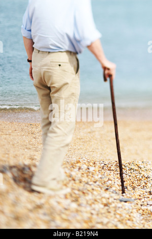 Hilfeleistung-Mann mit Spazierstock an einem Strand Stockfoto