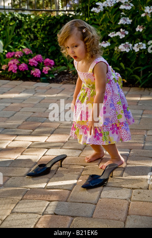 Ein zwei Jahres altes Mädchen bereitet sich auf ihre Mutter s Schuhe zu Hause in Südkalifornien zu versuchen Stockfoto