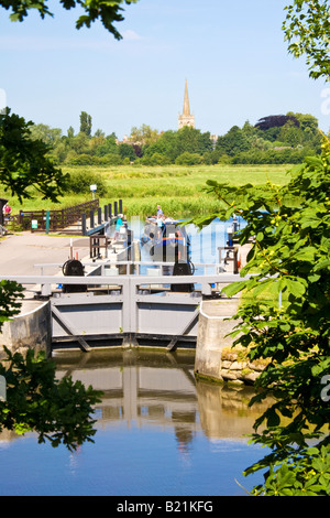 Narrowboat nähert sich St.Johannes Sperre auf der Themse, St.Lawrence Kirchturm im Hintergrund bei Lechlade, Gloucestershire, UK Stockfoto