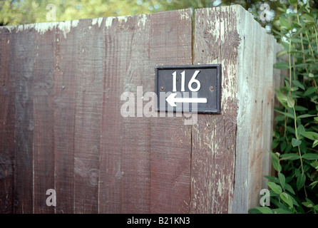 Nummer 116 mit einem nach links zeigenden Pfeil auf Garten Holzzaun Stockfoto
