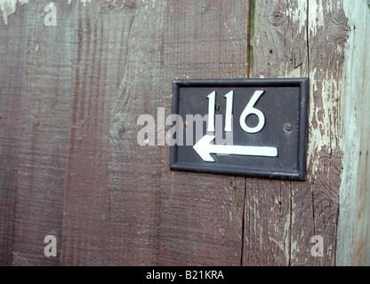 Nummer 116 mit einem nach links zeigenden Pfeil auf Garten Holzzaun Stockfoto