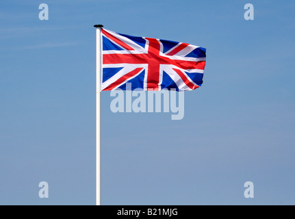 Union Jack-Flagge auf einer weißen Fahnenmast flattern im Wind. Stockfoto