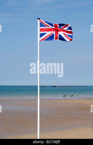 Union Jack-Flagge bei Mulberry Harbour, Gold Strand, Arromanches, Nord-Frankreich. Im Hintergrund zwei Pferd und Karren entlang reiten. Stockfoto