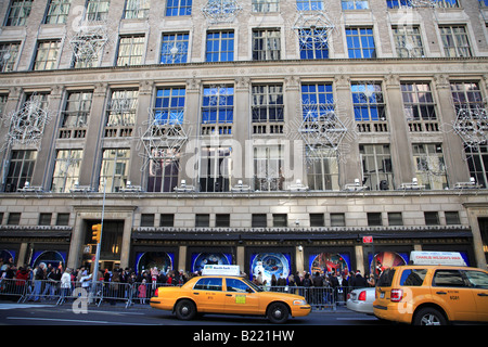 Menschenmassen Linie bis zu die Fenstern von Saks Fifth Avenue Kaufhaus dekoriert für Weihnachten Manhattan New York City USA anzeigen Stockfoto