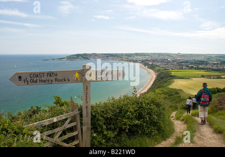 Wanderer am Küstenweg zwischen Old Harry Rocks und Swanage. Swanage Bay und Stadt in der Ferne Stockfoto