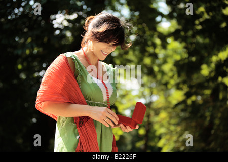 glückliche Mädchen lächelnd im Freien mit einem Schmuck-Box in den Händen Stockfoto
