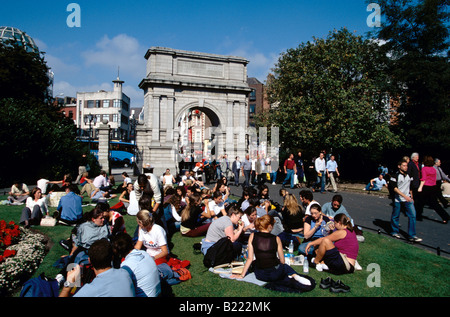 Junge Leute sitzen auf dem Rasen am St. Stephens Green Dublin Irland Stockfoto