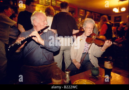 Mann und Frau spielt traditionellen Musik auf Geige und Querflöte an der Ecke Bar Skibbereen County West Cork Ireland Stockfoto