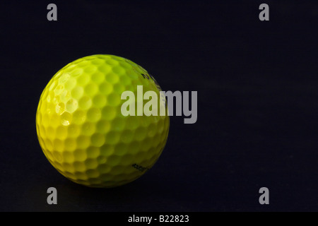 Ein gelber Golfball auf schwarzem Hintergrund ausgeschnittener Ausschnitt isoliert Nahaufnahme niemand horizontal in den USA Hi-res Stockfoto