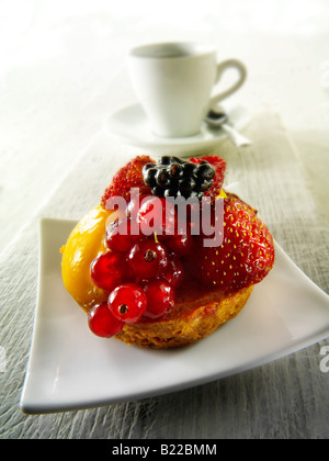 Eine frische Sommer Obst einzelnen Biskuitteig mit Himbeermousse in einem Café mit Kaffee Stockfoto