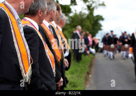 Reihe von Oranier zermürben Schärpen Uhr Pipe Band Spaziergang während der 12. Juli Orangefest-Feierlichkeiten in der Dromara Grafschaft Stockfoto