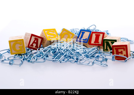 Kinder Blöcke Rechtschreibung aus "Benzin" auf einem Haufen von Metallketten Stockfoto