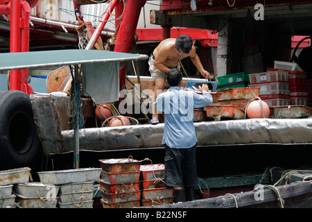 Chinesische Boot Leute entladen Fisch Körbe, Causeway Bay, Hong Kong Insel, China Stockfoto