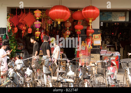 Käufer Fuß vorbei an einer Lampe Store in zentralen Shanghai. Fahrräder sind auf der Straße vor dem Laden geparkt. Stockfoto