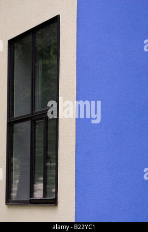 Ein schwarzes gerahmte Fenster auf einer weißen Wand. Die nächste Wand ist blau, ein abstraktes Bild zu schaffen. Stockfoto