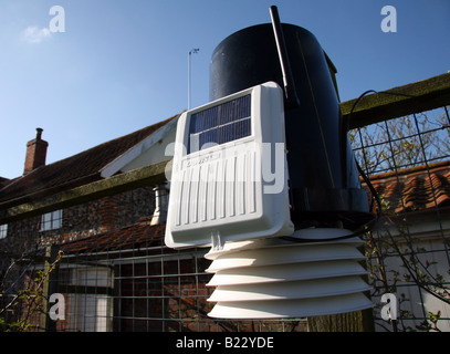 Eine solarbetriebene Davis Wetterstation montiert auf dem Zaun eines Suffolk-Cottage Stockfoto