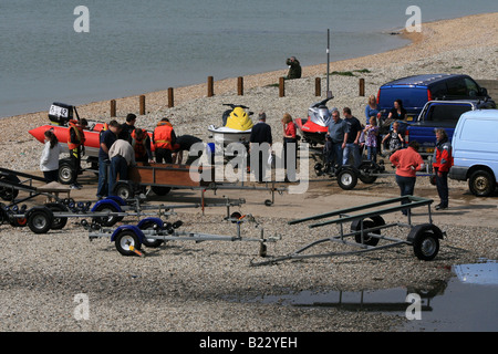 Menschen Sie be- und Entladen Boote und Jetskis bei Lee auf Solent Stockfoto